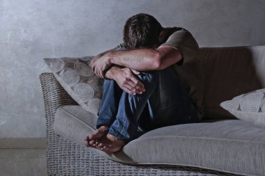 ağrı ve stresli hissediyor depresyon ve umutsuz yalnız acı anksiyete krizi ağlıyor gölgeli ev kanepe oturma üzgün ve depresyonda delikanlı yaşam tarzı dramatik ışık portresi