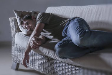 ağrı ve seyir uzağa düşünceli ve dalgın anksiyete sorunu acı kayıp hissi depresyon gölgeli ev kanepe, yatan genç üzgün ve depresyonda adam yaşam tarzı dramatik ışık portresi