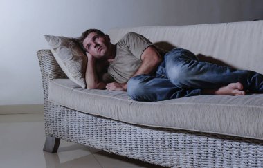 ağrı ve seyir uzağa düşünceli ve dalgın anksiyete sorunu acı kayıp hissi depresyon gölgeli ev kanepe, yatan genç üzgün ve depresyonda adam yaşam tarzı dramatik ışık portresi