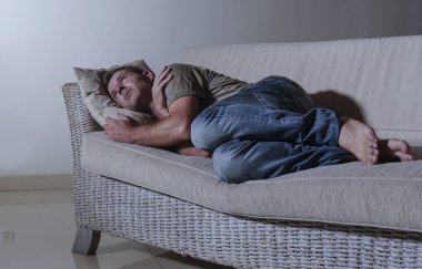 ağrı ve seyir uzağa düşünceli ve dalgın anksiyete sorunu acı kayıp hissi depresyon gölgeli ev kanepe, yatan genç üzgün ve depresyonda adam yaşam tarzı dramatik ışık portresi