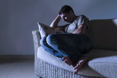 ağrı ve seyir uzağa düşünceli ve dalgın anksiyete sorunu acı kayıp hissi depresyon gölgeli ev kanepe oturma üzgün ve depresyonda delikanlı yaşam tarzı dramatik ışık portresi