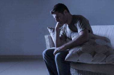 ağrı ve seyir uzağa düşünceli ve dalgın anksiyete sorunu acı kayıp hissi depresyon gölgeli ev kanepe oturma üzgün ve depresyonda delikanlı yaşam tarzı dramatik ışık portresi