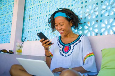 online dizüstü bilgisayar ve cep telefonu başarılı girişimci ve dijital göçebe yaşam tarzı ile çalışan kadın arayan genç çekici ve mutlu hipster açık havada portresi