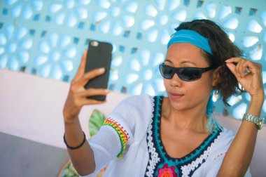 hareket eden telefon fotoğraf makinesi tatil seyahat güzel arka plan, eğlenceli ve neşeli poz ile selfie fotoğraf portre çekici genç mutlu ve çekici Güneydoğu Asya Endonezya kadın 