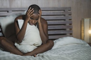 Genç üzgün ve depresyonda siyah afro Amerikan kadın endişeli ve endişeli depresyon sorunu ve uykusuzluk uyku bozukluğu acı seyir çaresiz hissediyor yatak uykusuz gece yarısı