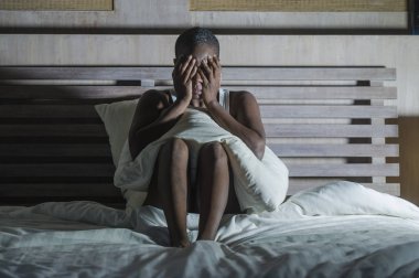 Genç üzgün ve depresyonda siyah Afrikalı-Amerikalı kadın endişeli ve endişeli depresyon sorunu ve uykusuzluk uyku bozukluğu acı seyir çaresiz hissediyor yatak uykusuz gece yarısı