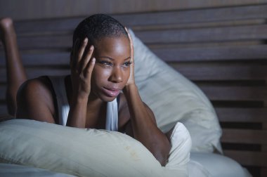 Genç üzgün ve depresyonda siyah afro Amerikan kadın endişeli ve endişeli depresyon sorunu ve uykusuzluk uyku bozukluğu acı seyir çaresiz hissediyor yatak uykusuz gece yarısı