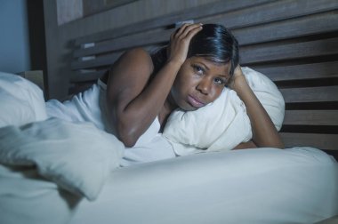 baş ağrısı ve depresyon ya da sorun uyku uykusuzluk yaşam tarzı gece portre genç üzgün ve endişeli siyah afro Amerikan kadın yatakta evde uykusuz ve stresli depresif duygu acı