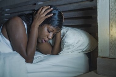 baş ağrısı ve depresyon ya da sorun uyku uykusuzluk yaşam tarzı gece portre genç üzgün ve endişeli siyah afro Amerikan kadın yatakta evde uykusuz ve stresli depresif duygu acı
