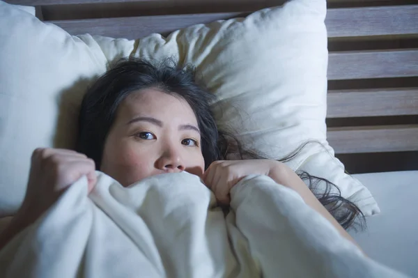 年轻的恐惧和紧张的生活方式的夜肖像亚洲华人妇女躺在床上遭受噩梦的恐惧和惊恐抓住毯子覆盖她的恐怖脸表情 — 图库照片