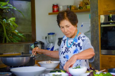 yaşam tarzı portre kıdemli mutluluk ve tatlı Asya emekli, Japon kadın evde yalnız temiz ve düzenli yaşlı ve olgun ev aşçı kavramı yemek hazırlama zevk mutfak yemek