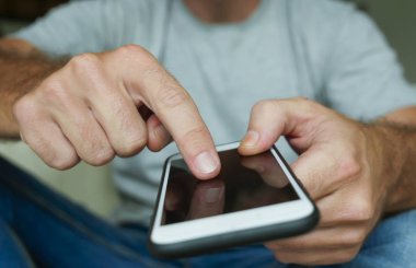 meçhul yaşam tarzı portre ile yakın çekim Genç adamın cep telefonu oturma evde kanepe koltuk smartphone ağ ve manifatura internet sosyal medya app kullanarak rahat tutan eller