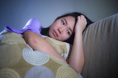 yalnız umutsuz ve endişeli evde oturan koltuk kanepe depresyon ve anksiyete sorun duygu yalnız ve çaresiz acı acı ağlayarak genç üzgün ve depresyonda Asyalı Japon kadın 