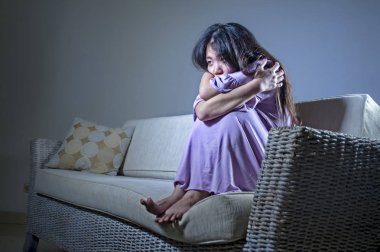 yalnız umutsuz ve endişeli evde oturan koltuk kanepe depresyon ve anksiyete sorun duygu yalnız ve çaresiz acı acı ağlayarak genç üzgün ve depresyonda Asyalı Japon kadın 
