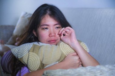 ev kanepe koltuk ağlıyor, Genç üzgün ve depresyonda Asyalı Koreli kadın umutsuz ve çaresiz acı anksiyete ve depresyon duygu ağrı ilişki ve yalnız hayat sorun kavramı