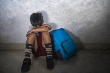 çocuk okul üniforması içinde 8 yaşında genç üzücü zorbalık kurbanı portresi korkmuş ve yalnız ağlamaya oturan sırt çantası depresif ve dayak bağımlılığı sorunu acı korkmuş dramatik yaşam tarzı