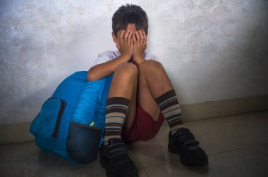 çocuk okul üniforması içinde 8 yaşında genç üzücü zorbalık kurbanı portresi korkmuş ve yalnız ağlamaya oturan sırt çantası depresif ve dayak bağımlılığı sorunu acı korkmuş dramatik yaşam tarzı