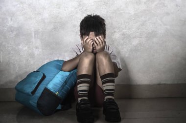 çocuk okul üniforması içinde 8 yaşında genç üzücü zorbalık kurbanı portresi korkmuş ve yalnız ağlamaya oturan sırt çantası depresif ve dayak bağımlılığı sorunu acı korkmuş dramatik yaşam tarzı