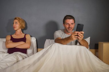 kocası ya da erkek yatakta ve ihanet şüphelenen ve adam kadın çift ilişki sorun kavram hile şüpheli sinirli eş ya da kız arkadaşı duygu üzgün cep telefonunuzun