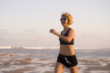 izole arka plan açık havada egzersiz fitness eğitimi ve sağlıklı sportif yaşam kavramı koşu içinde plajda çalışan genç mutlu ve çekici uygun kadın portresi