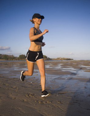 izole arka plan açık havada egzersiz fitness eğitimi ve sağlıklı sportif yaşam kavramı koşu içinde plajda çalışan genç mutlu ve çekici uygun kadın portresi