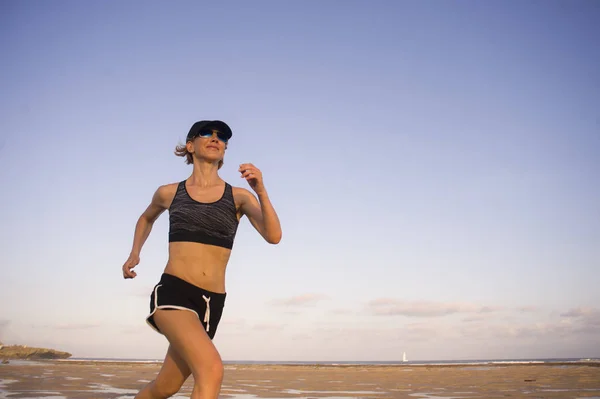 屋外ジョギング トレーニング フィットネス トレーニングで健康的なスポーティなライフ スタイルのコンセプトでビーチを走る楽しくて魅力的な若いフィット女性の孤立した背景の肖像画 — ストック写真