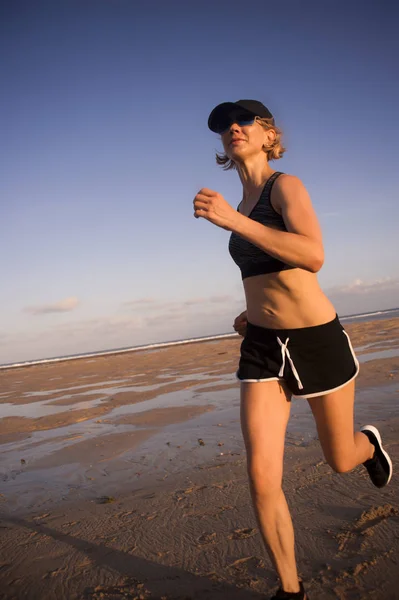 屋外ジョギング トレーニング フィットネス トレーニングで健康的なスポーティなライフ スタイルのコンセプトでビーチを走る楽しくて魅力的な若いフィット女性の孤立した背景の肖像画 — ストック写真