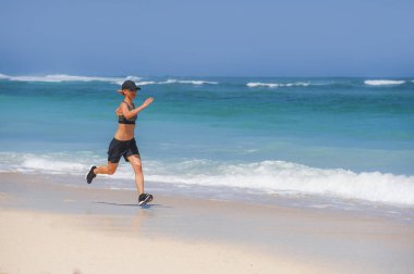 Genç mutlu ve çekici spor Çalıştırıcısı kadının çalışan egzersiz zinde ve atletik vücut sağlık fitness ve sağlıklı yaşam konsepti içinde gösterilen tropik cennet plaj Sprint yapması