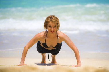 Sağlık fitness ve sağlıklı yaşam kavramı kum plaj neşeli gülümseyen üzerinde egzersiz yukarı itin genç mutlu ve güzel sportif ve formda kadının yapması izole portresi