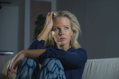 yaşam tarzı çekici ve üzgün bir kadın sinirli ve endişeli evde oturan koltuk kanepe anksiyete krizi ve depresyon sorunu düşünceli ve umutsuz acı depresif duygu dramatik portresi