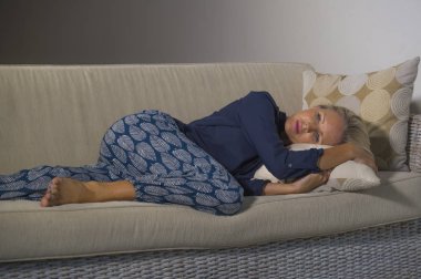 40'lı depresif ve endişeli güzel sarışın kadın depresyon duygu sinirli acı ve yalnız evde orta yaş krizi ve yaşam sorunu dalgın ve düşünceli kanepe koltuk yalan 