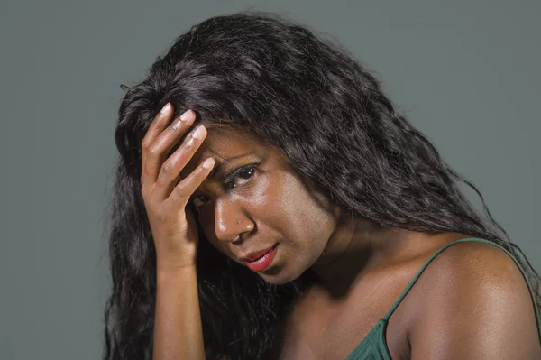 young attractive sad and depressed black African American woman feeling bad and desperate suffering anxiety crisis and depression problem isolated on studio background in intense face expression