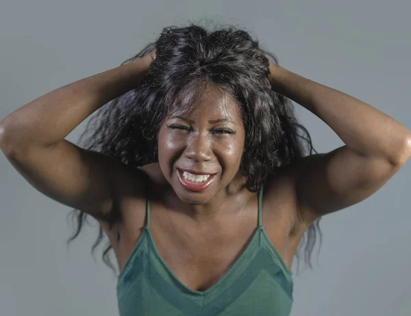 young crazy desperate and anxious black african American woman feeling stressed and tormented in intense and dramatic face expression isolated on studio background in stress and depression