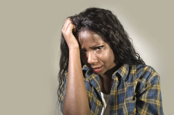 young sad and depressed black African American woman crying anxious and overwhelmed feeling sick and stressed isolated on studio background suffering depression problem and anxiety crisis