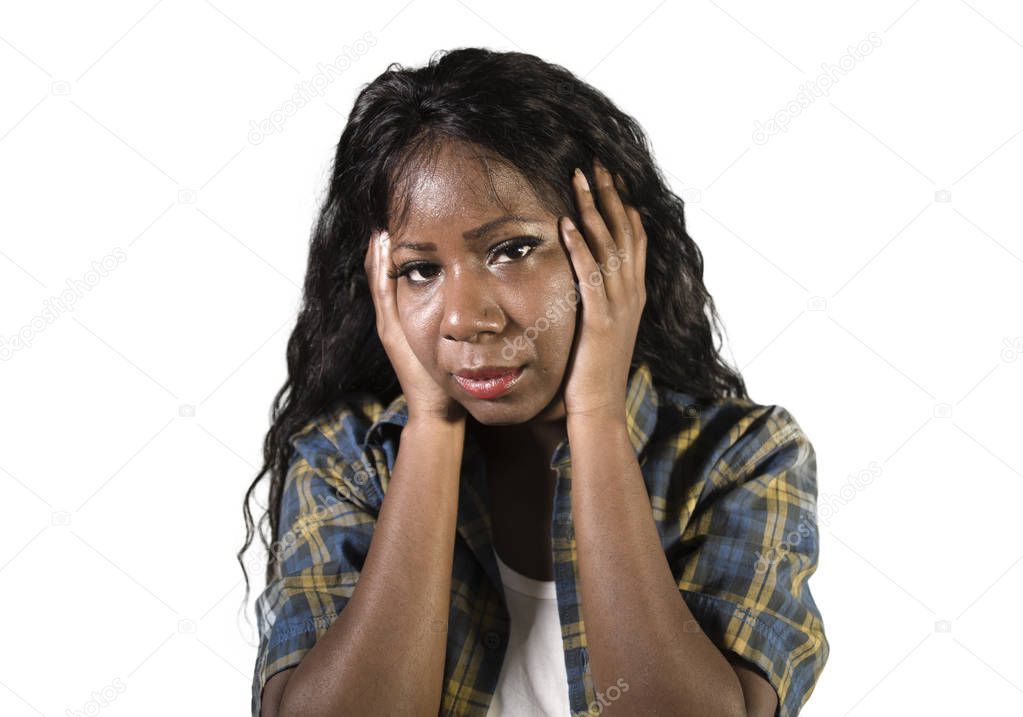 young sad and depressed black African American woman holding her head feeling sick and stressed isolated on studio background suffering depression problem and anxiety crisis