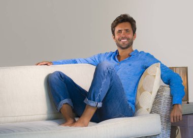 yaşam tarzı ev oturma odası kanepe koltuk modern dairesinde neşeli ve olumlu başarı kavramı içinde rahat ve konforlu oturma gülümseyen genç çekici ve mutlu 30'lu yaşlarda adam portresi