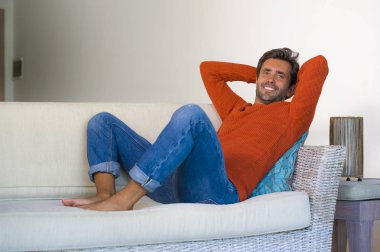 yaşam tarzı ev oturma odası kanepe koltuk modern dairesinde neşeli ve olumlu başarı kavramı içinde rahat ve konforlu oturma gülümseyen genç çekici ve mutlu 30'lu yaşlarda adam portresi