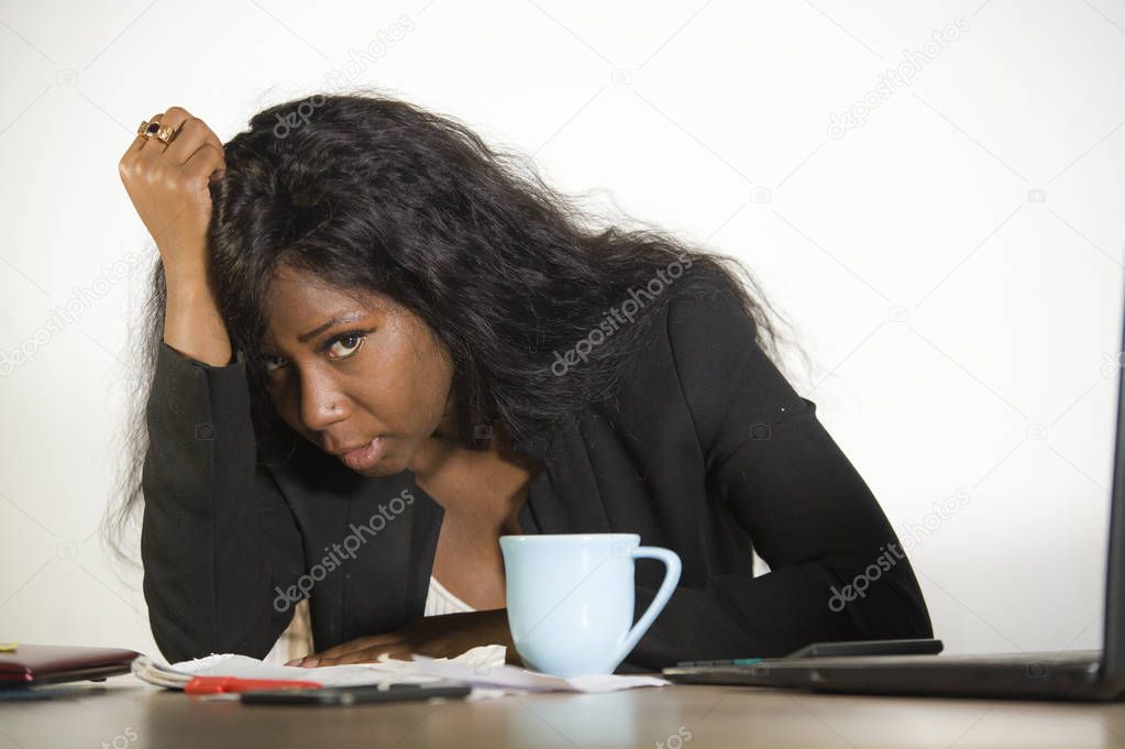 young depressed and overwhelmed black African American business woman working in stress at office computer desk feeling upset and overworked suffering depression and anxiety problem