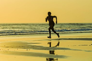 koşu ve günbatımı sağlıklı açık havada faaliyet zevk güzel Plajı'nda çalışan fitness sprint egzersiz egzersiz genç mutlu ve çekici Afro-Amerikan atlet kadın silüeti 