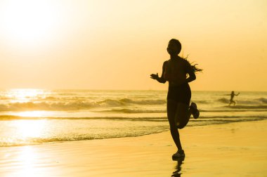 koşu ve günbatımı sağlık ve açık havada faaliyet zevk güzel Plajı'nda çalışan fitness egzersiz egzersiz genç mutlu ve çekici Afro-Amerikan atlet kadın silüeti 