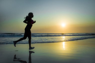koşu ve günbatımı sağlık ve açık havada faaliyet zevk güzel Plajı'nda çalışan fitness egzersiz egzersiz genç mutlu ve çekici Afro-Amerikan atlet kadın silüeti 