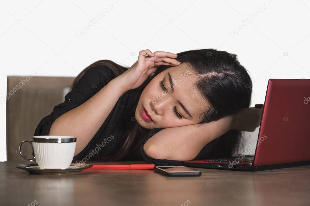 young beautiful sad and depressed Asian Chinese business woman working in stress at office computer desk feeling overwhelmed and frustrated suffering headache and depression isolated