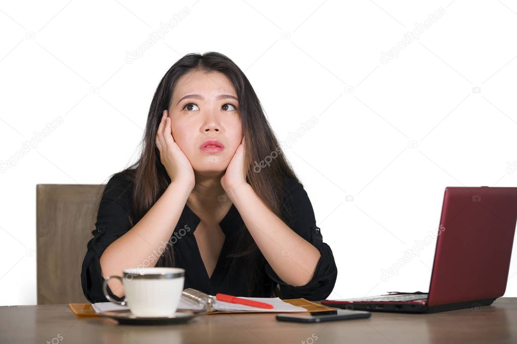 young beautiful sad and depressed Asian Korean business woman working in stress at office computer desk feeling overwhelmed and frustrated suffering headache and depression isolated