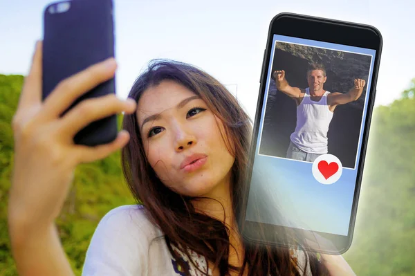 美しく 幸せなアジア中国女性メッセージのような愛とロマンスを探してハンサムな白人男性に送信する携帯電話のインターネット オンライン出会い系アプリを使って — ストック写真