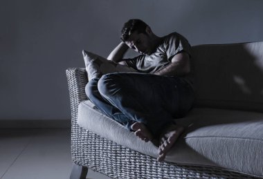 evde kanepe koltuk depresyon sorunu ve anksiyete krizi ağlıyor çaresiz ağrı hissi hasta ve hasta üzerinde dramatik ışık acı acı çekiyor genç umutsuz üzgün ve sinirli adam