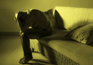 evde kanepe koltuk depresyon sorunu ve anksiyete krizi ağlıyor çaresiz ağrı hissi hasta ve hasta üzerinde dramatik ışık acı acı çekiyor genç umutsuz üzgün ve sinirli adam