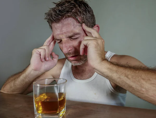 年轻的浪费和沮丧的酒精成瘾人在肮脏的单线饮杯威士忌感觉绝望的痛苦酗酒问题和酗酒成瘾的背景在酒精概念 — 图库照片