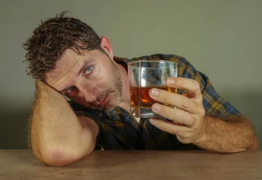 Genç dağınık depresif alkollü adam alkol bağımlılığı alkolizm sorun acı günaha düşen viski cam bakarak içki içiyorum izole portresi