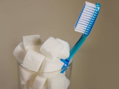 diş fırçası ve ferahlık cam diş bakımı ve ağız hijyeni kavram dişlerde çürük neden tatlı beslenme istismar üzerine uyarı olarak kesme şeker dolu izole kavramsal natürmort resim