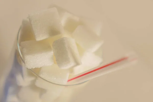 砂糖の立方体とカロリーと栄養カロリー乱用のブドウ糖中毒不健康な超過分の白い背景で隔離のわらの完全リフレッシュ ガラスの概念マクロ静物イメージ — ストック写真
